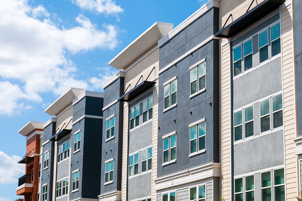 Ein modernes Mehrfamilienhaus von außen mit dunkelblauen Elementen